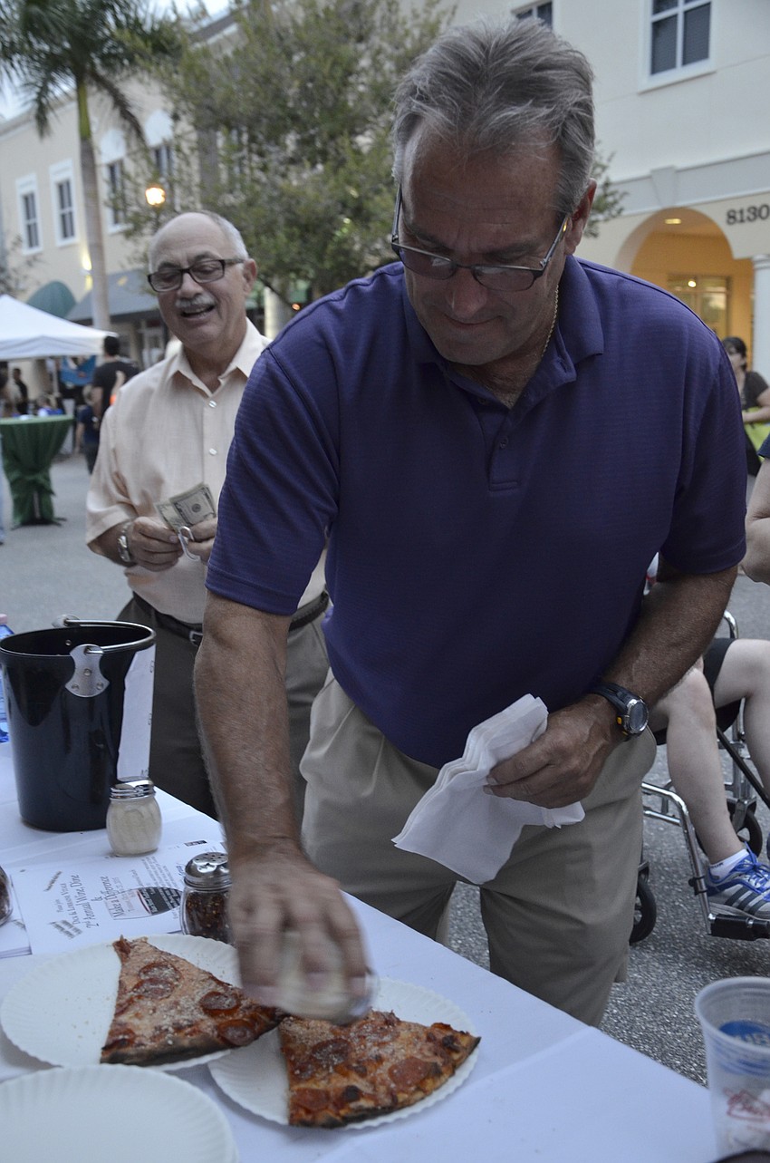 Gerry Smith, a Bradenton resident, cheeses up a piece of pizza from Main Street Trattoria.