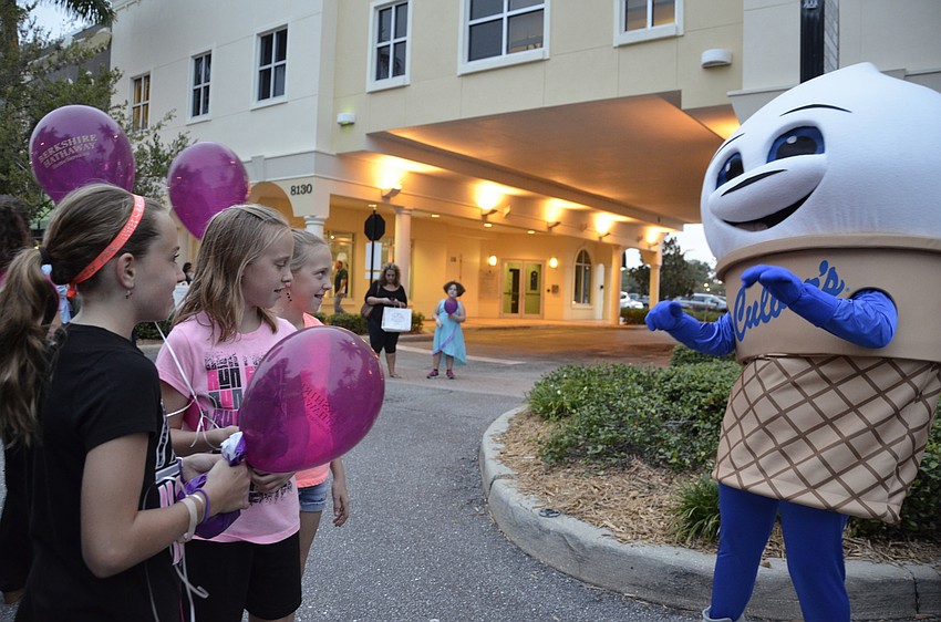 Mackenzie Lawson and Celia and Faye Swartz, sixth-graders at Braden River Middle School, get free samples from Scoopy the Culver's mascot.