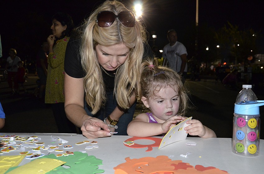 Heritage Harbour resident Mandy Bowyer helps her daughter, Stella, at the craft table.