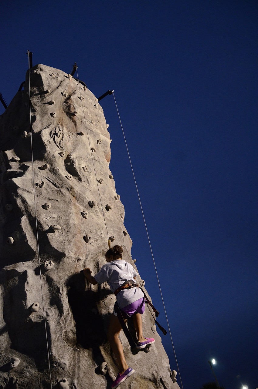 Stephanie Greene, a YMCA swim team member, treks the climbing wall.
