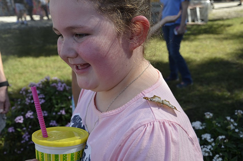 Emma-Grace Gonyaw of Lakeland stands very still to keep from scaring the butterfly on her shoulder.