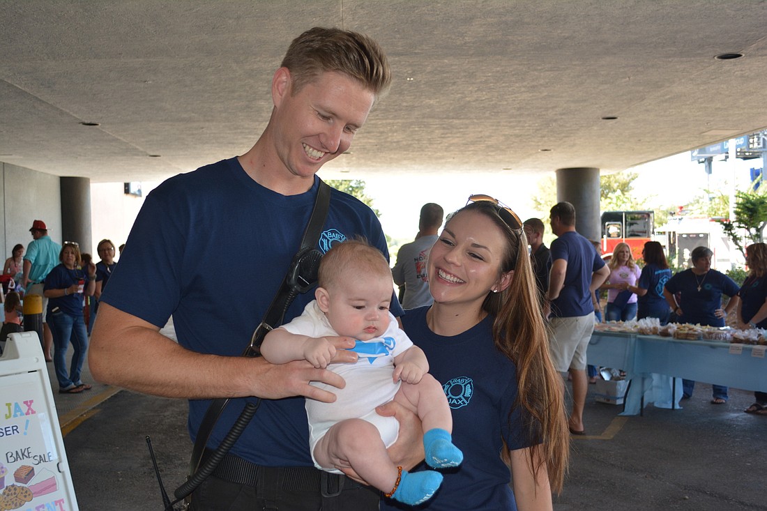 Donald and Kara Bunch hold their 5-month-old baby Jaxson during a fundraiser on Saturday at the Ellenton Ice and Sports Complex to help pay medical costs for the baby's illness.