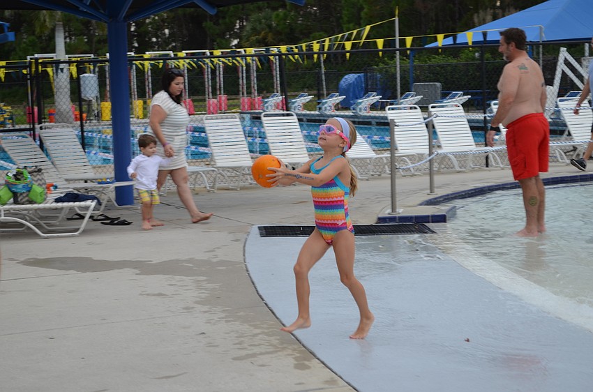 Emilia Young emerges from the Water Park pool with a pumpkin in hand.
