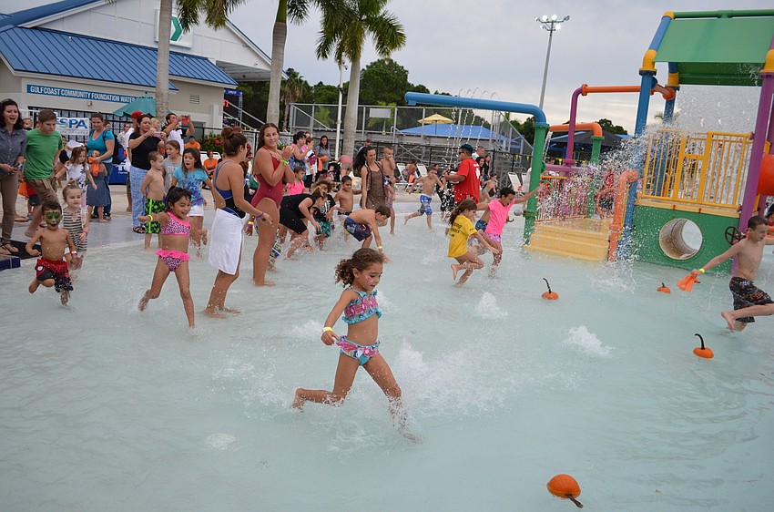 Children rush into the waters in the hopes of taking home a pumpkin.