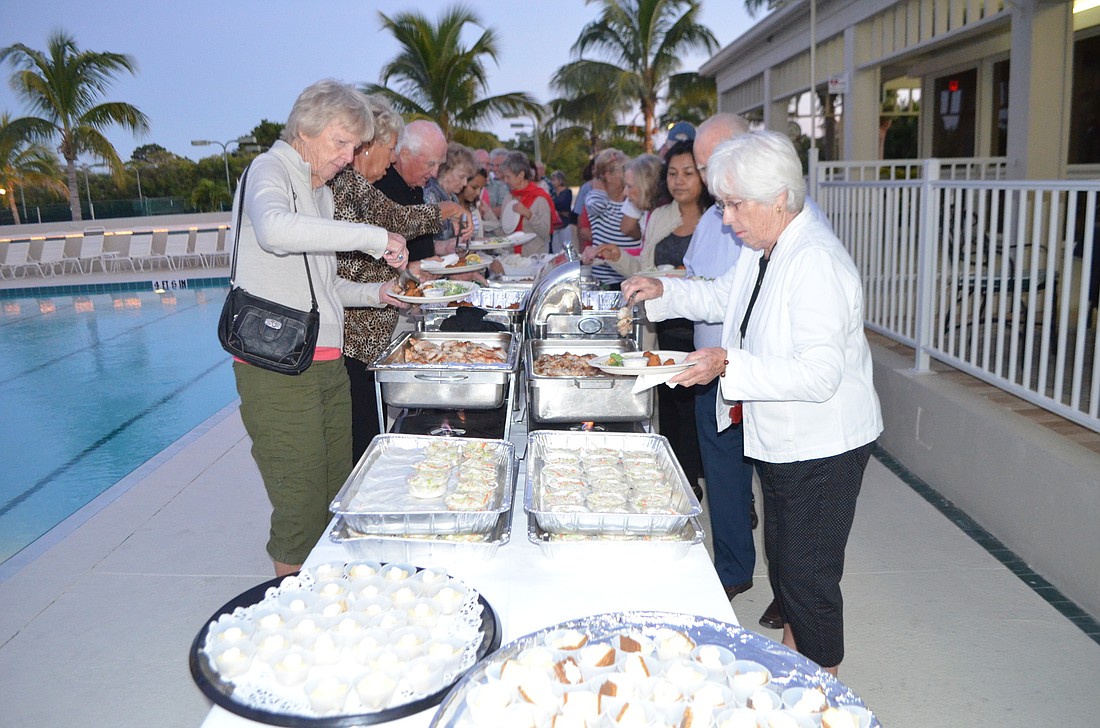 Attendees fill their plates with salad, hush puppies, friend and grilled fish, coleslaw and key lime pies at last yearâ€™s fish fry.