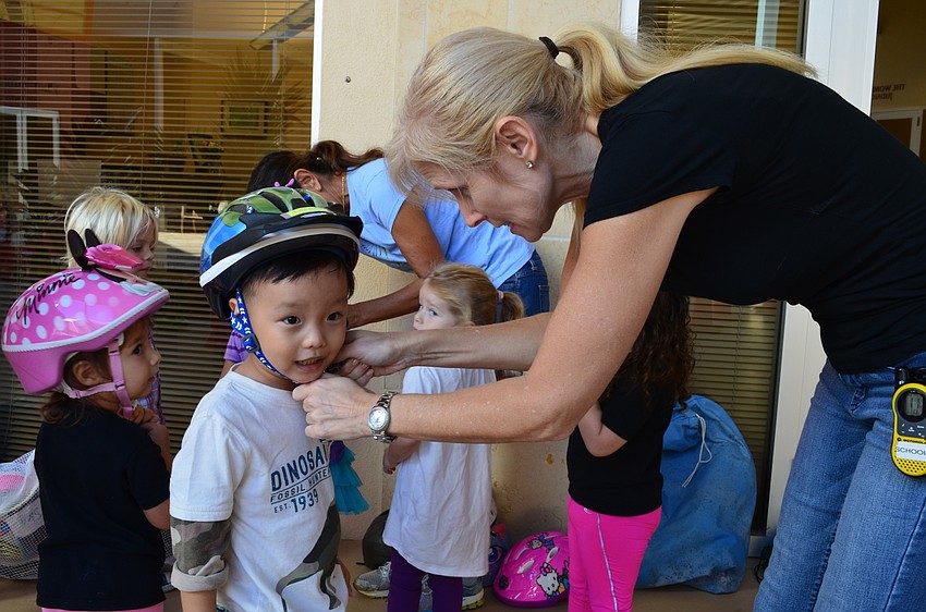 The Gan Director Laura Freedman helps Andrew Yang with his helmet.