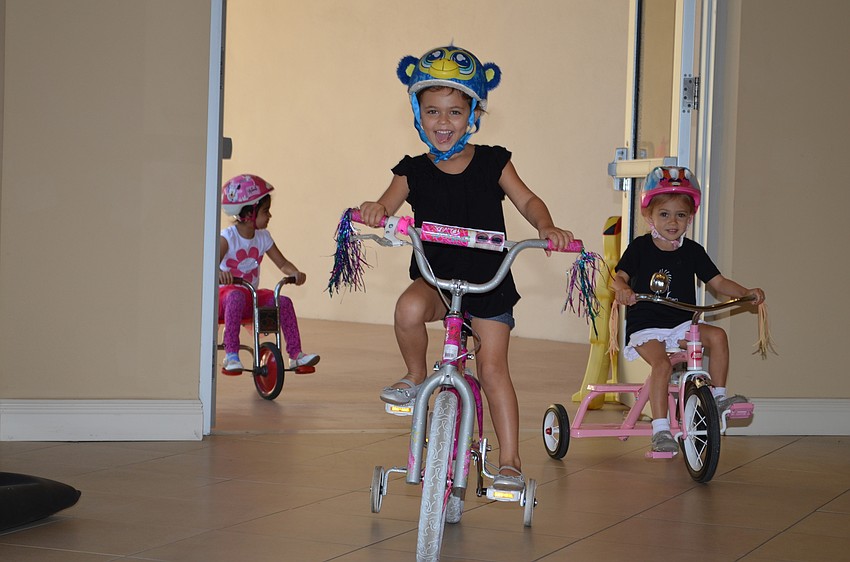 Liv Yavitz is delighted to be able to ride her tricycle through the Temple Sinai lobby.