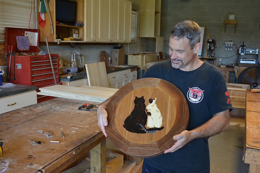 Ron Massaro shows off a lazy Susan he made using the art of marquetry.