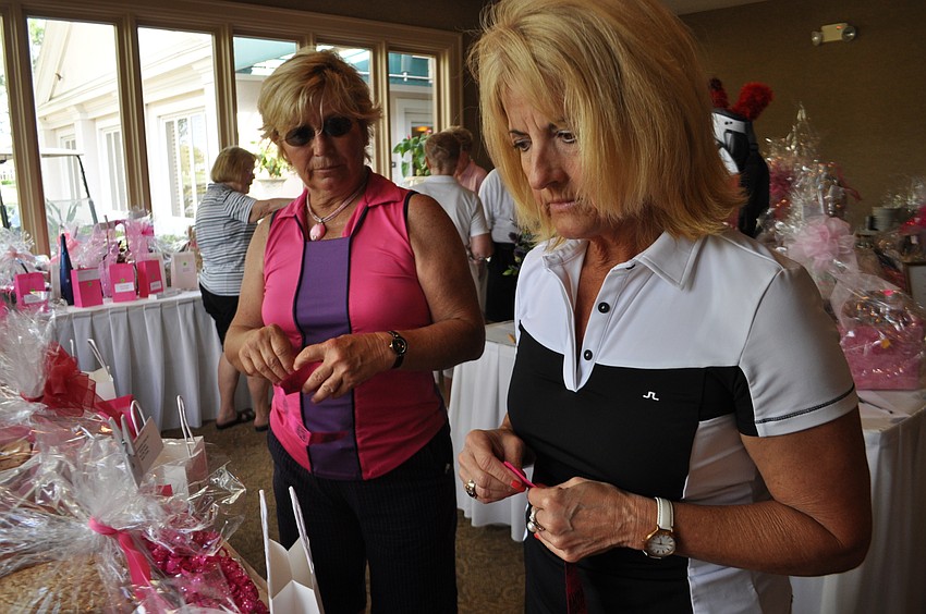 Kathleen Homan, front, and Dee Donegan, behind, put their tickets in for raffle items.