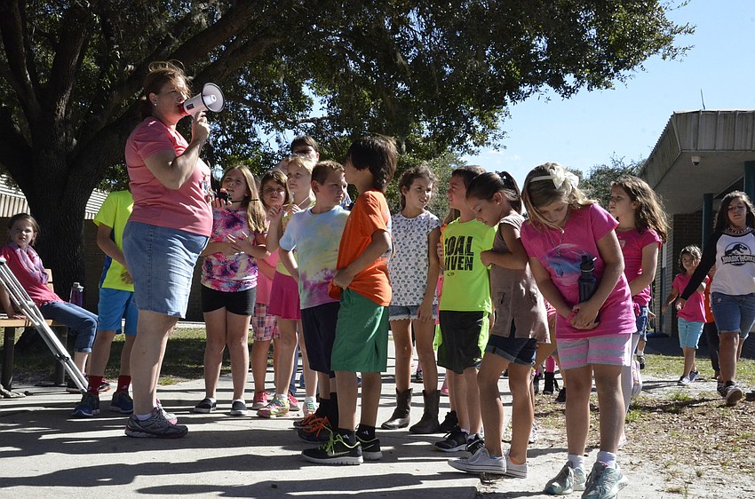 Third-grade teacher Kim Hoy directs students to start the walk.
