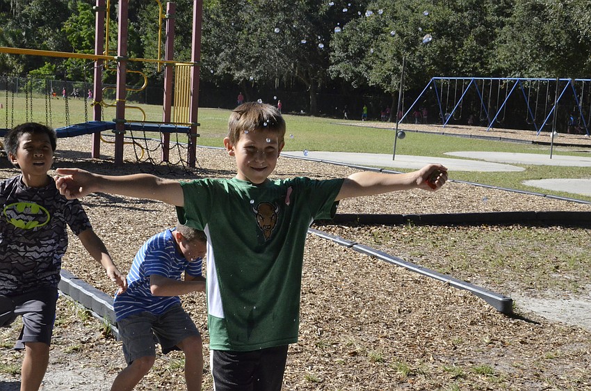 Justin Tong, Matthew Tabor and Logan Matyasi get showered by a water shooter.