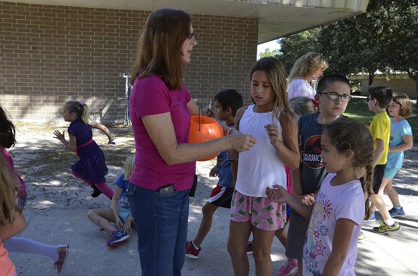 First-grade teacher Lesley Spence hands out popsicle tickets.