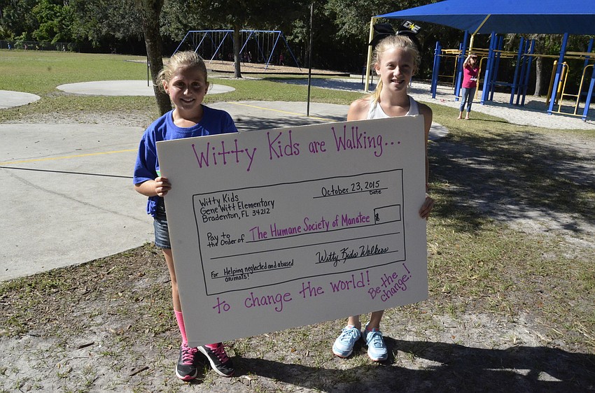Ryann Hilyer and Sydney Rice hold the donation check before the total was figured.