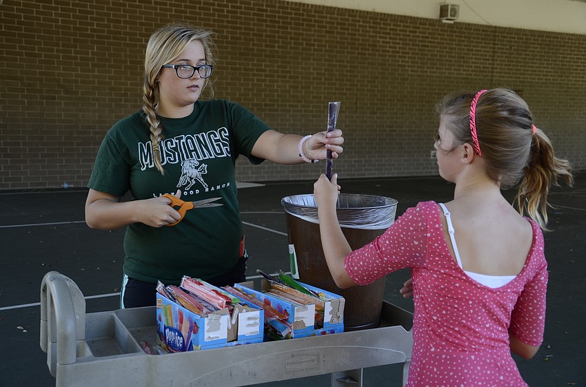 Katie Onstine gets a popsicle from volunteer Taylor Hilyer. Hilyer, a sophomore at Lakewood Ranch High School,  is the older sister of one of the walk-a-thon organizers, Ryann Hilyer.