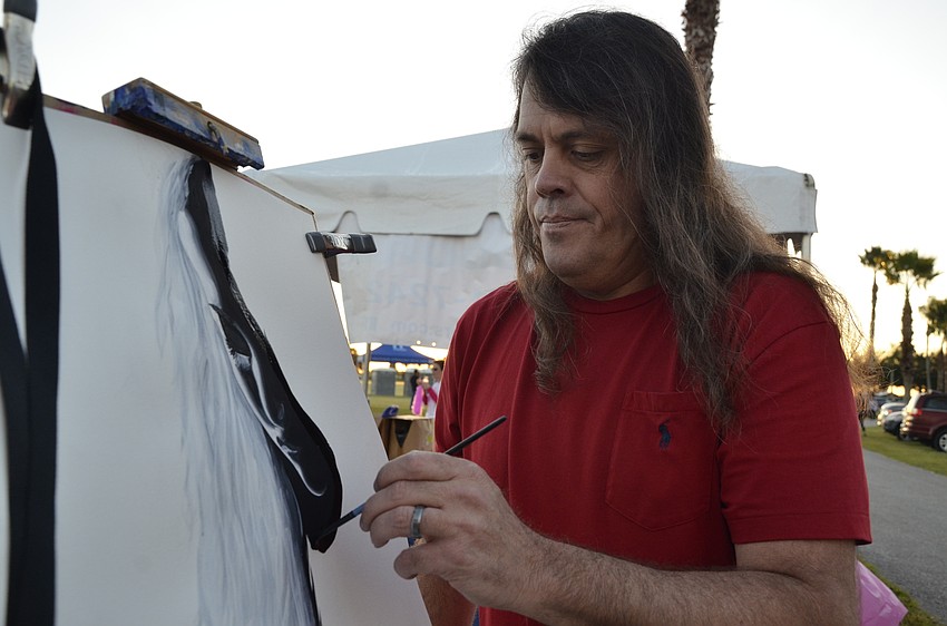 Bradenton artist Brandon Scott makes a painting to be raffled.