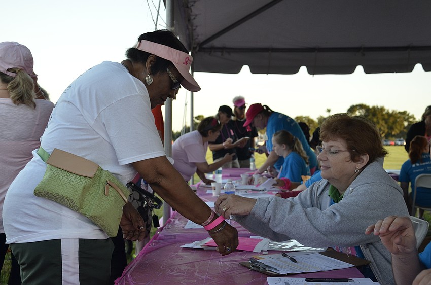 Volunteer Mary Romines helps Sarasota resident Gwen Atkins check in.