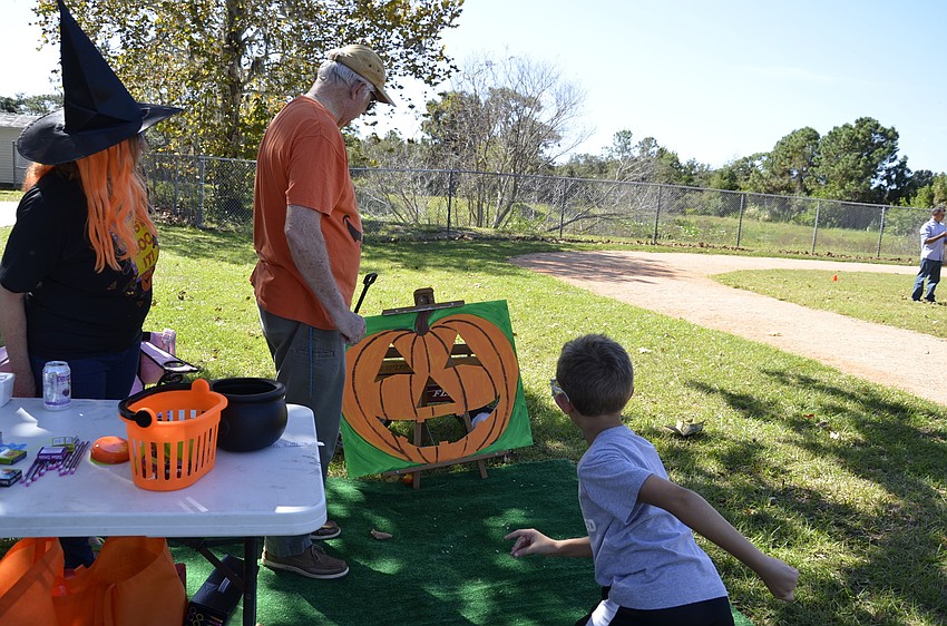 Nico Anzalone wins the pumpkin toss. Jack and Pat Knowlton, the art teacher, ran the booth.
