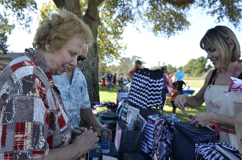 Tom Kema and his wife, Sue, a substitute at Tara, check out the personalized gifts form Karen Hoskinson and her business, thirty-one.