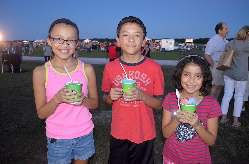 Sera, Elliott and Ava Nelson, of East County, snack on snow cones.