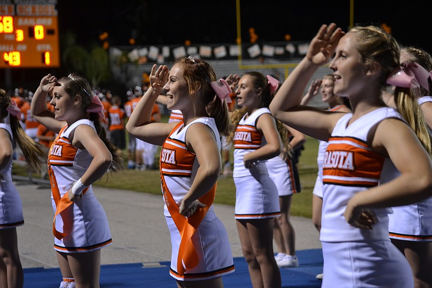 Sarasota High School Cheerleaders Kaitlyn Needham, Christina Berberich and Hope Bumbgarner salute following a cheer.