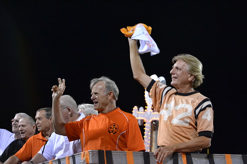 Stan Long and John Stenglien wave to the crowd during the halftime homecoming procession.