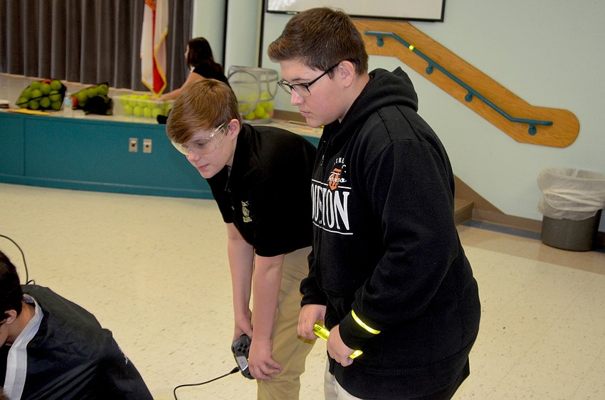 Woodland Middle students Camden Swope and Jonathan Sickon watch their competitors showcase their robots' speed and accuracy.