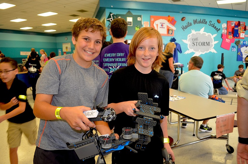 Sarasota Middle students Aden Vilardi and Cobi Gibson gather the remains of their robot, which came a part after the launcher got caught.