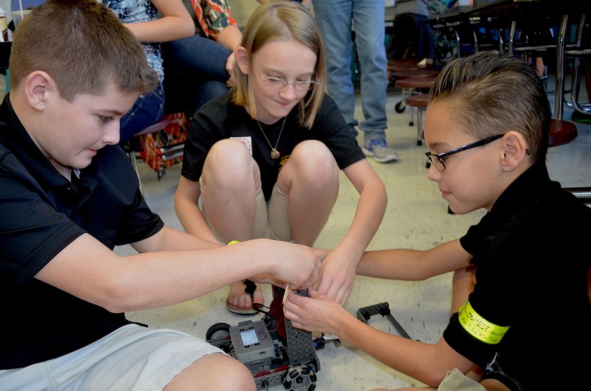 Andrew Cabana, Sabrina Eutsler and Ethan Klein put the finishing touches on their robot.