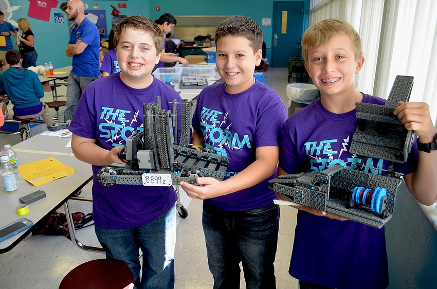 Haile Middle students Nathan Ianero, Rafael Alonso and Trevor Davis show off their STEM research project and robot, which runs off electromagnetic propulsion.