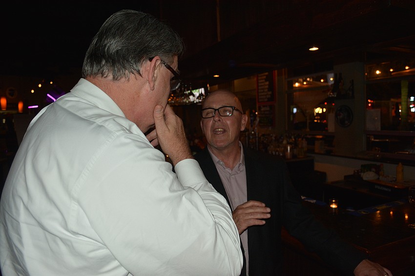 Gary Fennessy visits with Jim Roque just before dinner is served on Tuesday night.