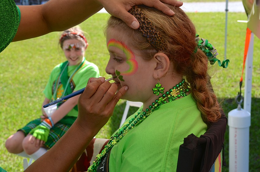 Karson Redmon sits still so Akiko can paint her face.