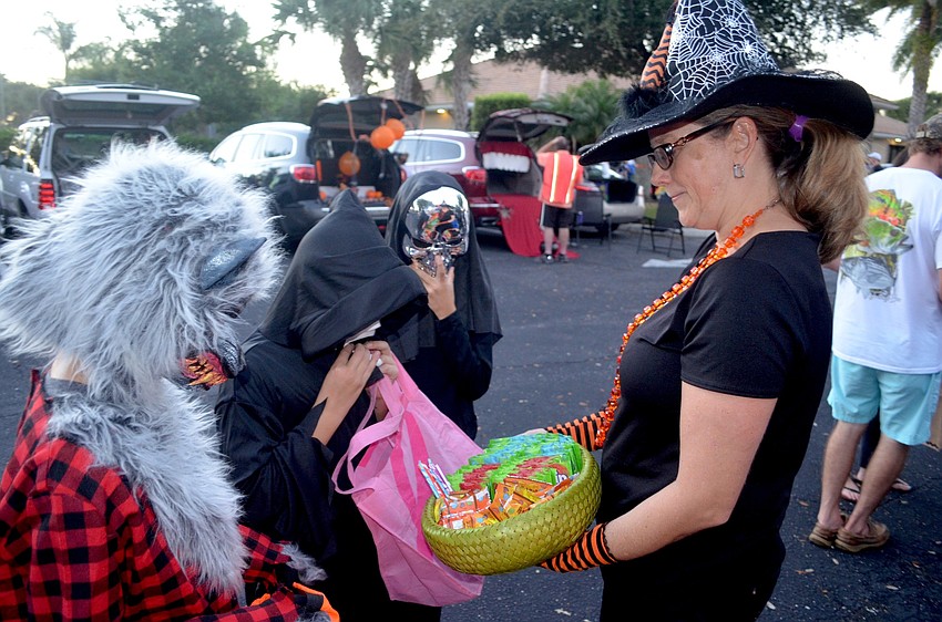 Kirsten Parker dishes out candy to children in the parking lot of the Stoneybrook Recreation Center.