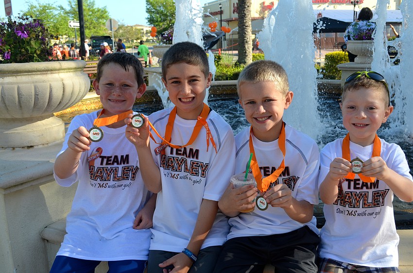 Friends and event participants Landen Sutterby, Trey and Tyler Clinton and Riese Unger rest near the fountain to cool off.