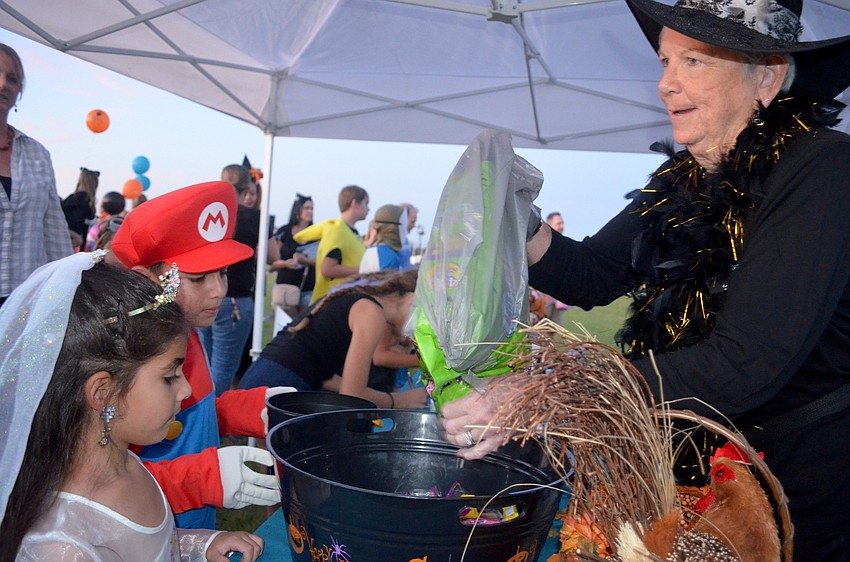 Lena and Sami Judeh, of GreyHawk Landing, collect candy from Jane Welsh.