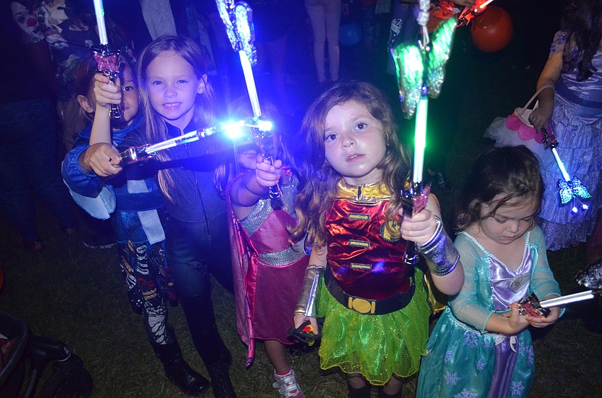 Children whip around light-up wands.