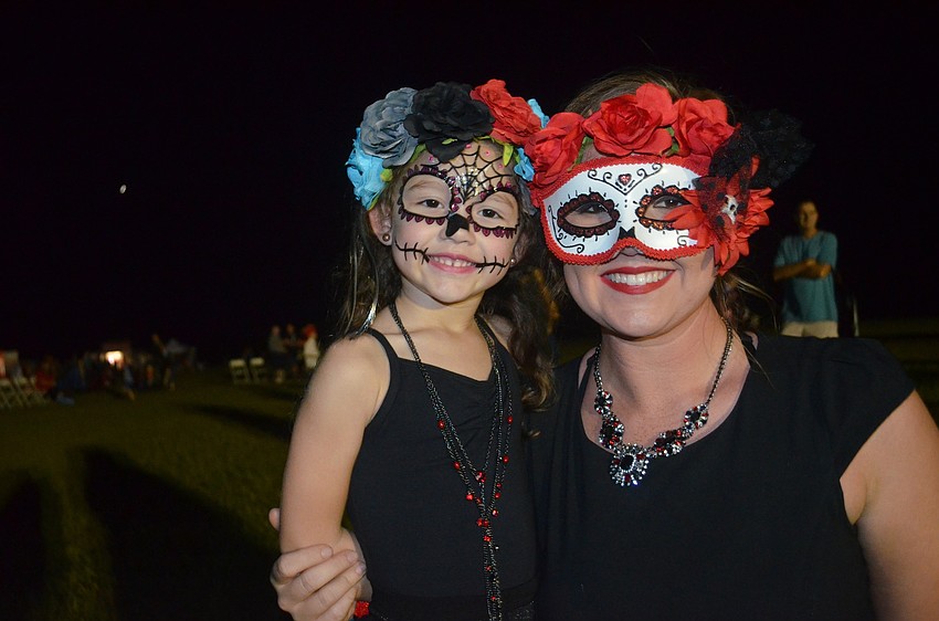 Scarlett Reynolds and her mother, Britni, of Lakewood Ranch, wear masks and other face decor.