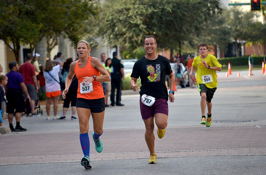 Jamie Kauffold, of Lakewood Ranch, is the first female runner to finish the race. She runs alongside Luis Velasques, of Lakewood Ranch.