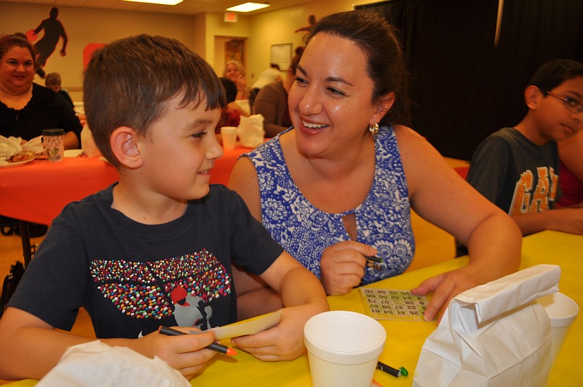 ogan and Christine Collins smile as they mark on their bingo cards.