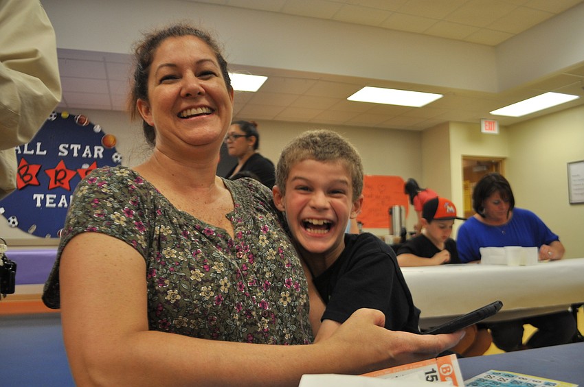Joy Davenport can’t help but smile as her son, Kameron, goes wild after winning bingo.