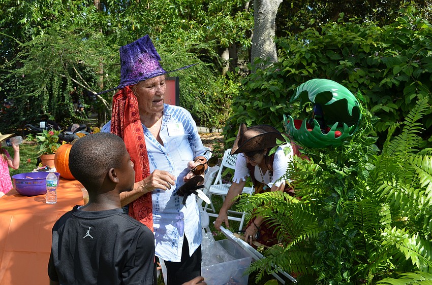 Marie Selby Botanical Gardens volunteer Lynn Grow helps Aterious Edwards play a game called Horticulture's Hair-Raising Herbarium.