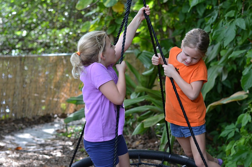 Pals Katheleen Siddons and Ella McConnell spin on a swing.