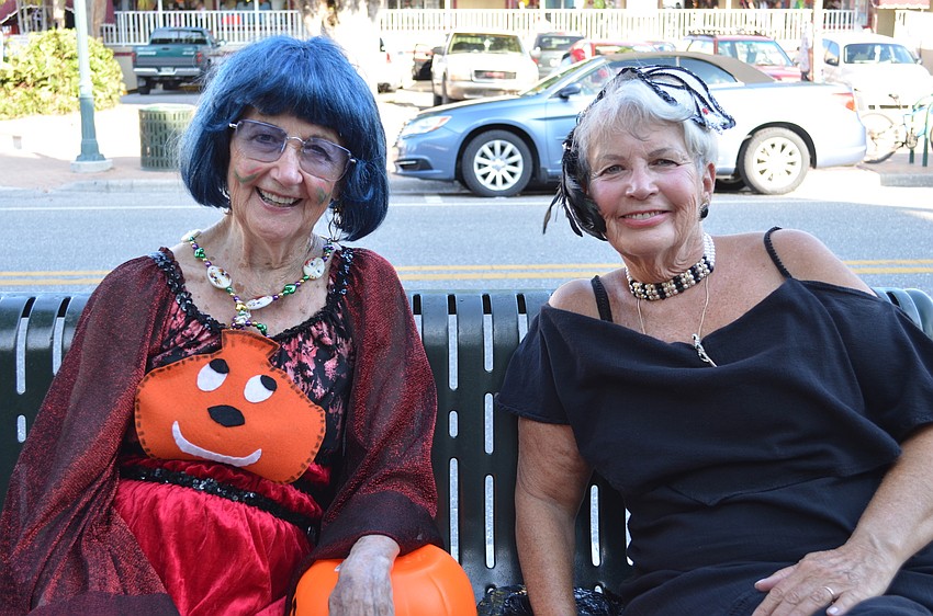 Siesta Key residents Jeanene Kortjohn and Diane Erhe hand out candy to children in the village.