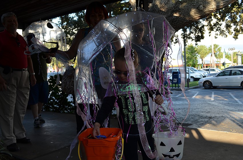Ryleigh Stockton dressed as a jellyfish reaches for candy.