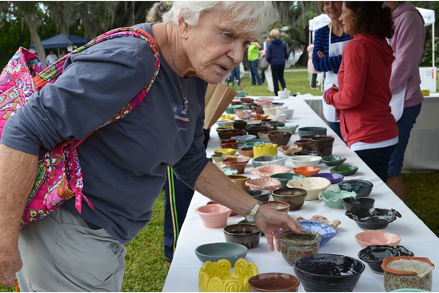 Barb Thomason decides which bowl to take home from Bowls of Hope last year.