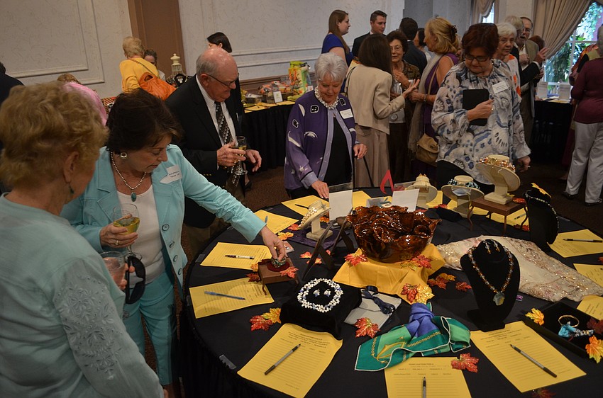 Guests look over the silent auction items at Key Chorale's annual luncheon at Michael's On East.
