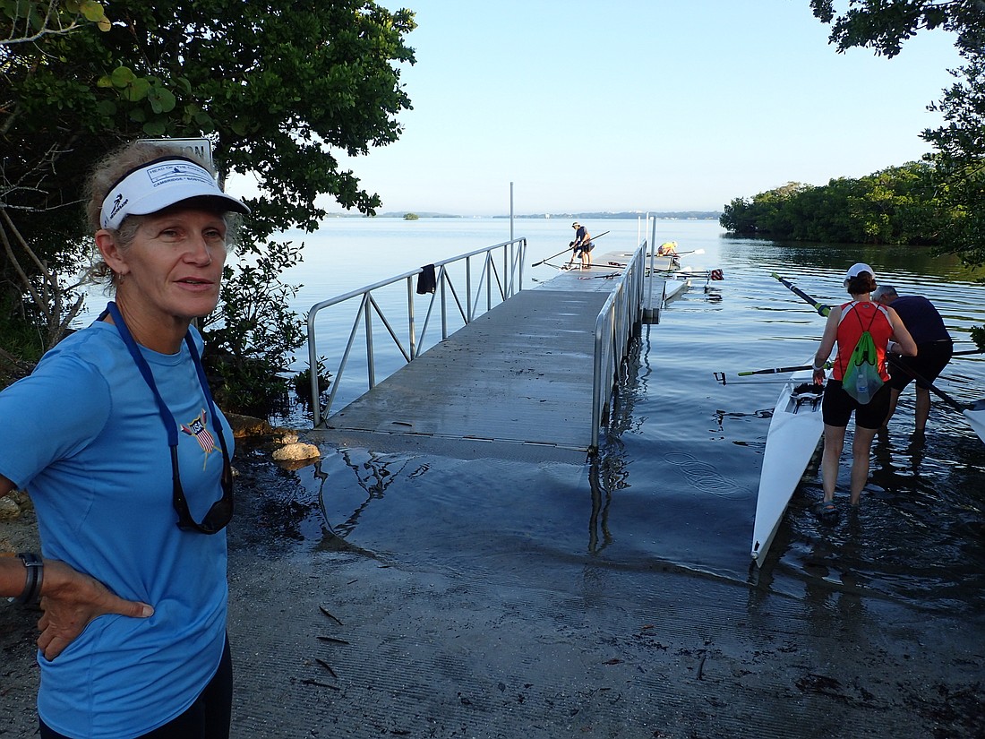 Betsy Mitchell  stands at the base of the ramp, where the dock at Blackburn Point Park is partially submerged. At high tide, she said, the water reaches the spot where she stands.