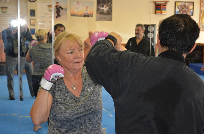 Corrine Wagner, an employee of Coldwell Banker in Lakewood Ranch, gets instruction from martial arts instructor Jessie Vi.