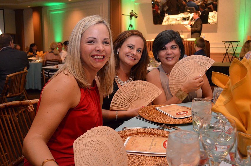 Sonia Espinel, Edith Barrales and Mary Gutierrez use the fans to cool down before dinner.