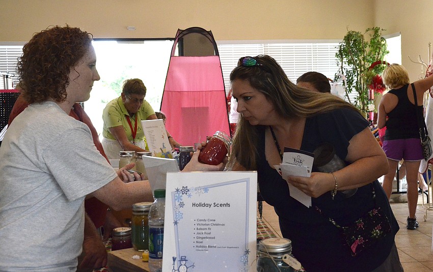 Megan Lawson with Oceanside Candles lets Kelly Hayer sample a scent.