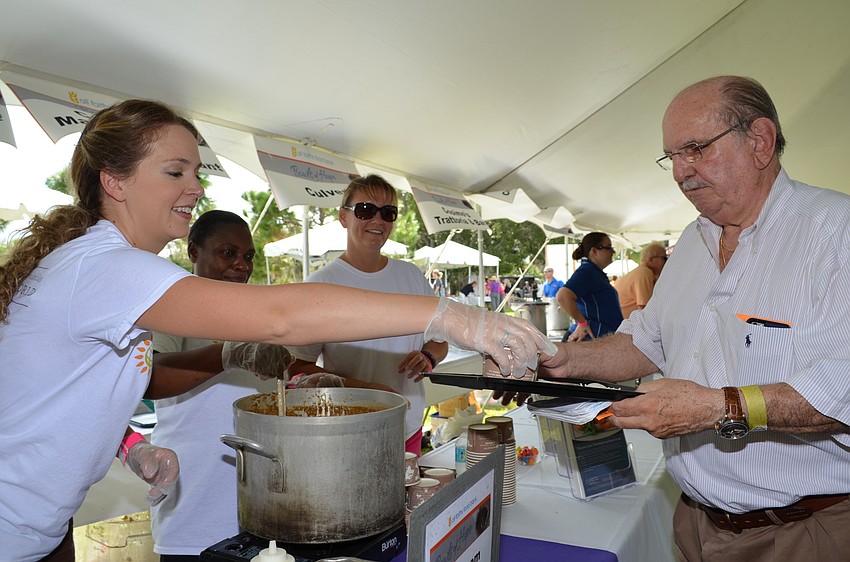 Stephanie Murphy serves Frank Dursl a portion of mushroom bisque with chive and black pepper creme fraiche from the Hyatt Regency.